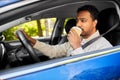 tired indian man or driver with coffee driving car