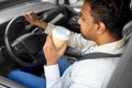 tired indian man or driver with coffee driving car
