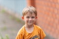 Tired and joyful boy stands on the street after playing with friends