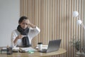 Tired lady freelancer sitting at desk at home office looking sickly at digital thermometer Royalty Free Stock Photo