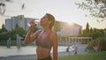 Tired lady replenishing water balance fitness workout at evening nature closeup Royalty Free Stock Photo