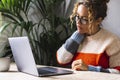 Tired lady touching neck for pain and stressed muscles while use laptop. Bad posture sitting at the table office workplace concept Royalty Free Stock Photo