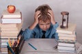 Tired of the lessons of the European boy at the table with books Royalty Free Stock Photo