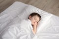 Tired little boy sleeping in bed, happy bedtime in white bedroom