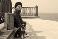 Tired little girl sitting on the road with a dog