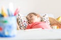 Tired little preschooler girl sleeping in comfortable chair near desk Royalty Free Stock Photo