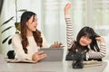 Tired little schoolgirl sitting at desk with her mother, feeling bored or fatigue doing homework Royalty Free Stock Photo