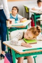 tired little schoolgirl sleeping on desk