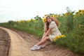 a tired lonely girl is resting sitting on the edge of a rural dirt road Royalty Free Stock Photo