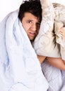 A tired looking man in bed. He is holding a pillow Royalty Free Stock Photo