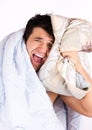 A tired looking man in bed. He is holding a pillow Royalty Free Stock Photo