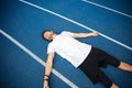 Tired male athlete resting after running while lying on racetrack Royalty Free Stock Photo