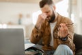 Tired Male Holding Glasses Massaging Nosebridge Sitting At Laptop Indoors Royalty Free Stock Photo