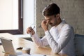 Millennial office worker taking off eyeglasses suffers from eyes strain