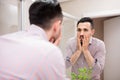 Tired man checking his face in mirror Royalty Free Stock Photo