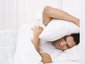 Tired Man Hiding His Head with Pillow Royalty Free Stock Photo