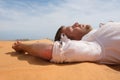 Tired man lying on the sand in a desert. Royalty Free Stock Photo