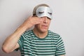 tired man in a sleep mask on a gray background, insomnia of the elderly concept, sleep problems