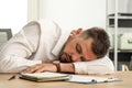 Tired man sleeping at workplace in office Royalty Free Stock Photo