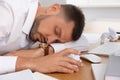 Tired man sleeping at workplace in office Royalty Free Stock Photo