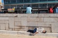 Tired man taking a nap on stones at the Ulus Square in Ankara, Turkey