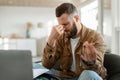 Tired Man Touching Nosebridge Sitting At Laptop Holding Eyeglasses Indoor Royalty Free Stock Photo