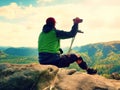 Tired man tourist sit with hurt knee in immobilizer or rock, hold medicine pole. Open forest landscape