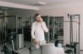 a tired man wipes sweat from his face with a towel after working out on a treadmill. cardio workout Royalty Free Stock Photo