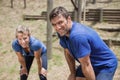 Tired man and woman bend down with hands on knees during obstacle course Royalty Free Stock Photo