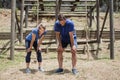 Tired man and woman bend down with hands on knees during obstacle course Royalty Free Stock Photo