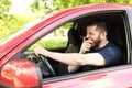 Tired man yawning while driving his car Royalty Free Stock Photo