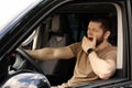 Tired man yawning while driving his modern car Royalty Free Stock Photo