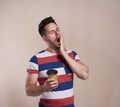 Tired man yawning and holding disposable cup of coffee Royalty Free Stock Photo
