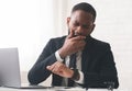 Tired manager checking time and yawning at workplace Royalty Free Stock Photo