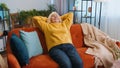 Tired senior woman enjoy relaxing on home sofa resting napping after hard working day closed eyes Royalty Free Stock Photo