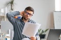 Tired mature male office worker working with documents and having problems, sitting at desk in office Royalty Free Stock Photo