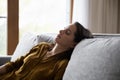 Tired millennial young woman sleeping in sitting position on couch