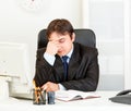 Tired modern businessman sitting at office desk