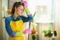 Tired modern woman with mop in modern living room in sunny day