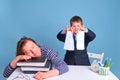 Tired mom of naughty boy schoolboy sleeping at school desk, blue background