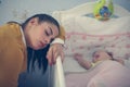 Tired mother dreaming next to baby. Royalty Free Stock Photo