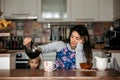 Tired mother, trying to pour coffee in the morning. Woman lying on kitchen table after sleepless night