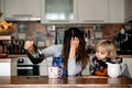 Tired mother, trying to pour coffee in the morning. Woman lying on kitchen table after sleepless night