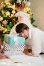 Tired of New Year& x27;s bustle, man lies on boxes with gifts at home Christmas tree