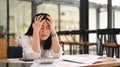 Tired office worker holding her head, feeling strong headache, exhausted from overwork or stress at work Royalty Free Stock Photo