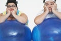 Tired Overweight Couple Resting On Exercise Balls