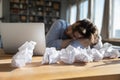 Tired overworked businessman sleeping at desk covered crumpled papers