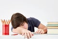 Tired and overworked caucasian teenager pupil felt asleep at the desk while doing his homework. Royalty Free Stock Photo