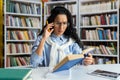 Tired overworked female student studying alone in university library, woman not understanding complex material, studying