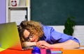 Tired overworked female teacher sleeping on desk in classroom. Back to school. Knowledge day. Student preparing for Royalty Free Stock Photo